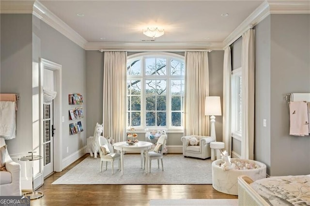 living area featuring crown molding and hardwood / wood-style floors