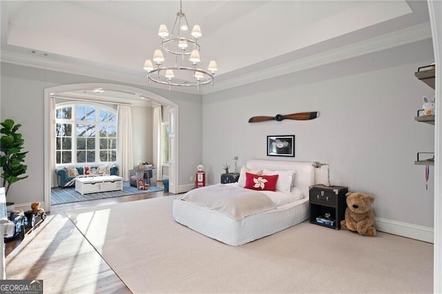 bedroom featuring a raised ceiling, crown molding, and an inviting chandelier