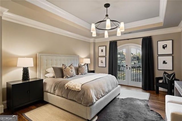 bedroom featuring ornamental molding, access to exterior, a raised ceiling, dark wood-type flooring, and french doors