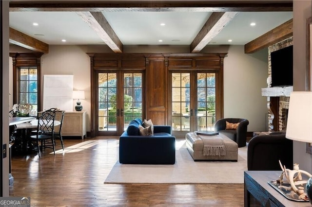 living room with beamed ceiling, a healthy amount of sunlight, and french doors