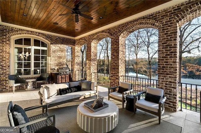 view of patio featuring a water view, ceiling fan, grilling area, and an outdoor hangout area