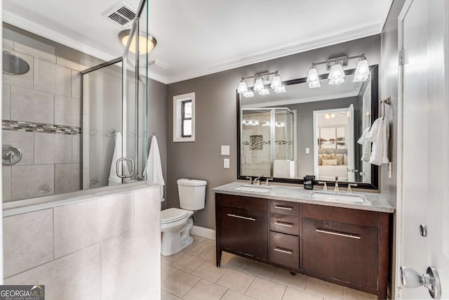 bathroom featuring ornamental molding, vanity, and a shower with shower door