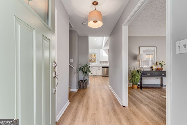 hallway featuring a textured ceiling and light wood-type flooring