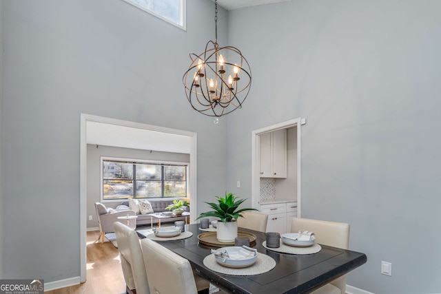 dining area with plenty of natural light, a notable chandelier, and light wood-type flooring