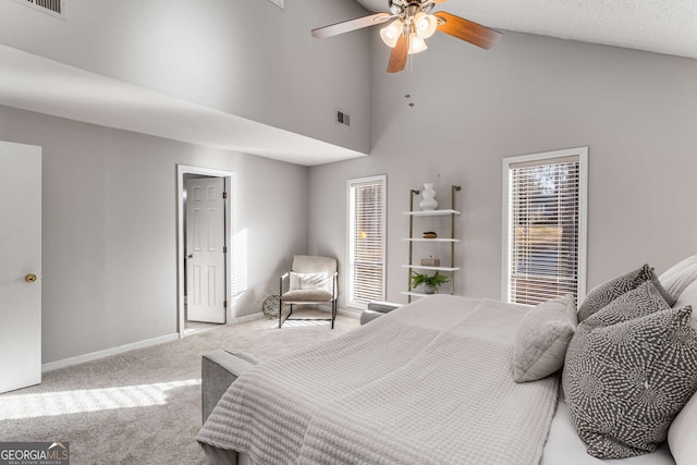 bedroom featuring ceiling fan, light colored carpet, and a high ceiling