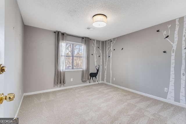 carpeted spare room featuring a textured ceiling