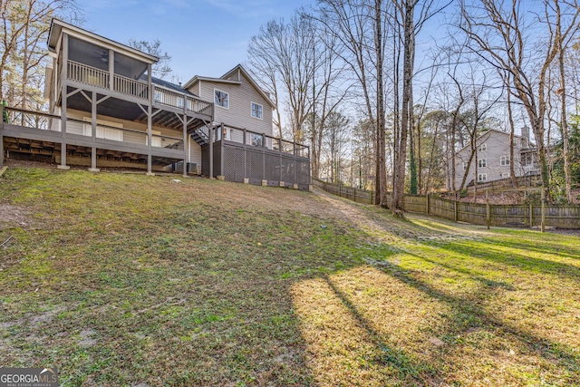 view of yard with a wooden deck, a sunroom, and ceiling fan