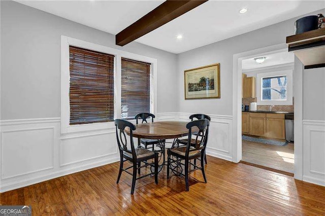 dining area featuring beamed ceiling and dark hardwood / wood-style floors