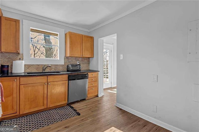 kitchen with sink, crown molding, stainless steel dishwasher, and tasteful backsplash