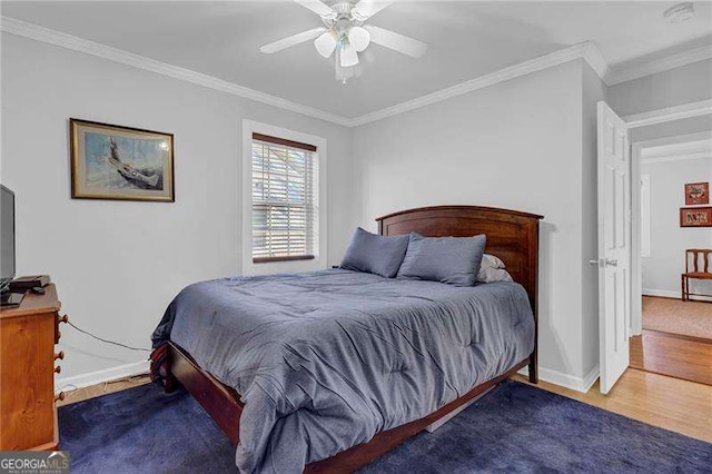 bedroom featuring hardwood / wood-style flooring, ceiling fan, and ornamental molding