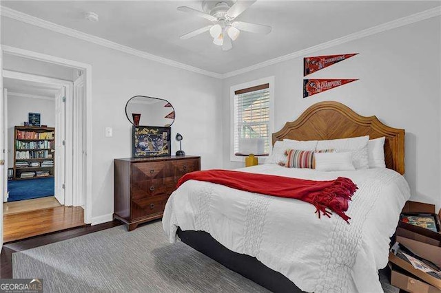 bedroom featuring crown molding, wood-type flooring, and ceiling fan