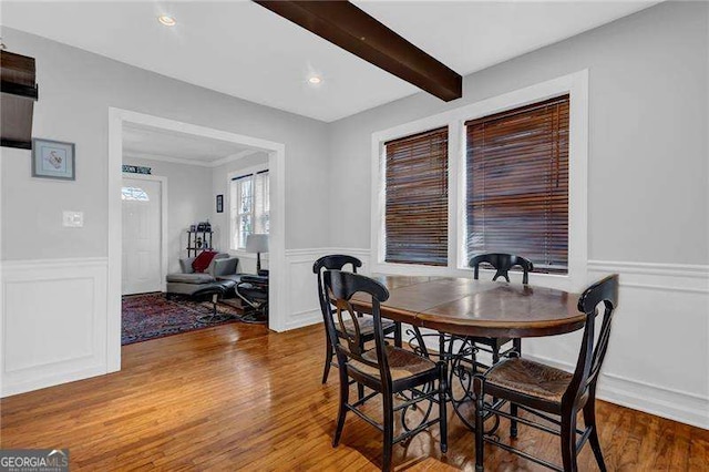 dining space with beam ceiling and hardwood / wood-style floors