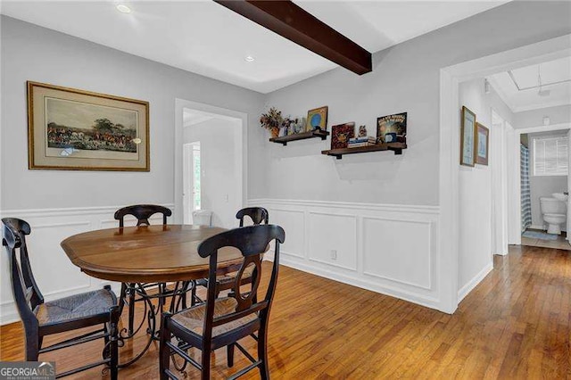 dining space featuring hardwood / wood-style floors and beamed ceiling