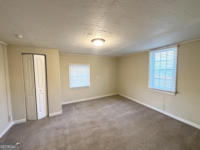 interior space with a textured ceiling, a closet, and carpet flooring