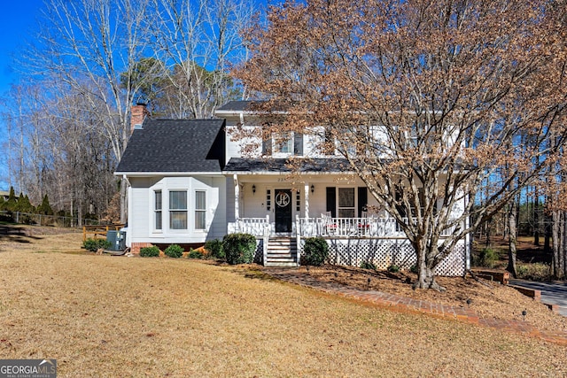 view of front of house featuring central AC, covered porch, and a front lawn