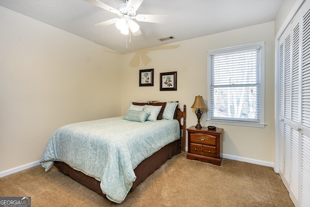 carpeted bedroom with ceiling fan and a closet