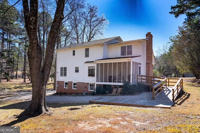 back of house featuring a sunroom and a deck