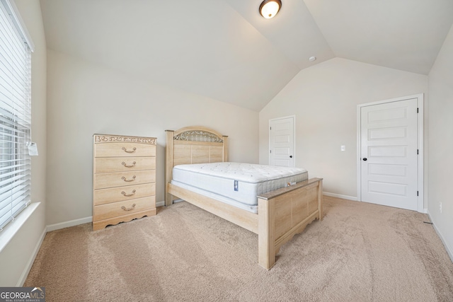 unfurnished bedroom with multiple windows, light colored carpet, and lofted ceiling