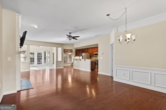 unfurnished living room featuring ceiling fan with notable chandelier and dark wood-type flooring