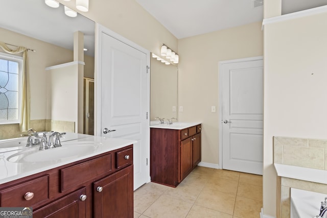 bathroom with vanity, tile patterned floors, and a tub to relax in