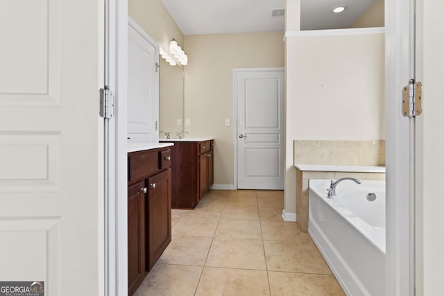 bathroom featuring tile patterned floors, vanity, and a tub to relax in