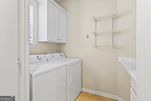 laundry area with cabinets, separate washer and dryer, and light tile patterned flooring