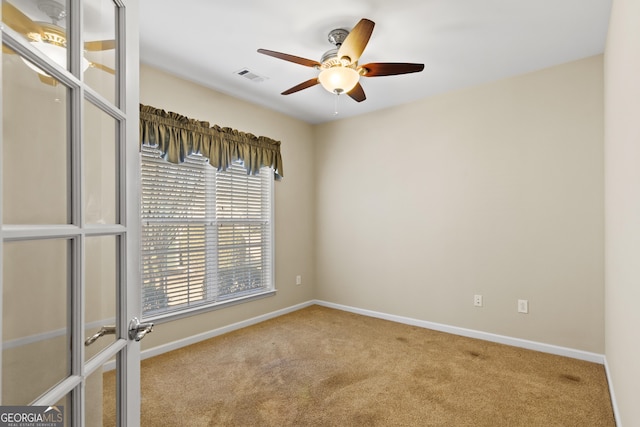 carpeted spare room with ceiling fan