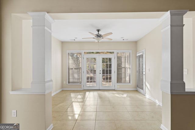 tiled empty room featuring french doors, ceiling fan, and ornate columns