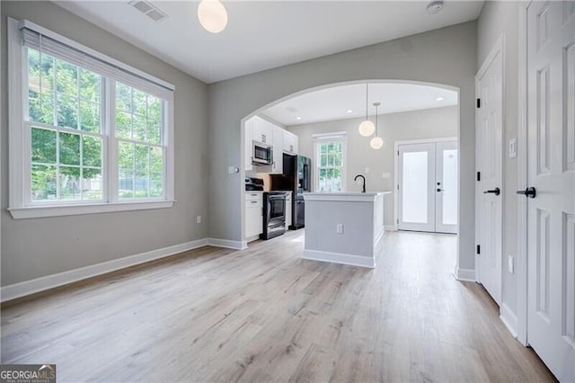 kitchen with arched walkways, visible vents, appliances with stainless steel finishes, and white cabinetry