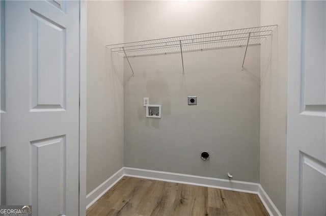 washroom featuring electric dryer hookup, baseboards, washer hookup, and wood finished floors