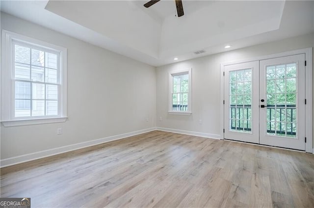 empty room featuring french doors, baseboards, visible vents, and wood finished floors