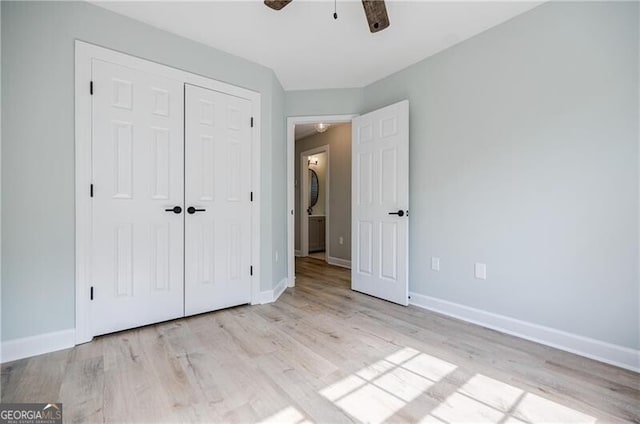 unfurnished bedroom featuring a ceiling fan, wood finished floors, baseboards, and a closet