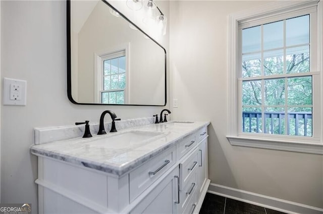 bathroom with double vanity, plenty of natural light, and a sink