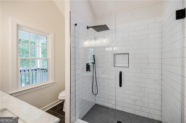 bathroom featuring vanity, a shower stall, vaulted ceiling, tile patterned floors, and toilet