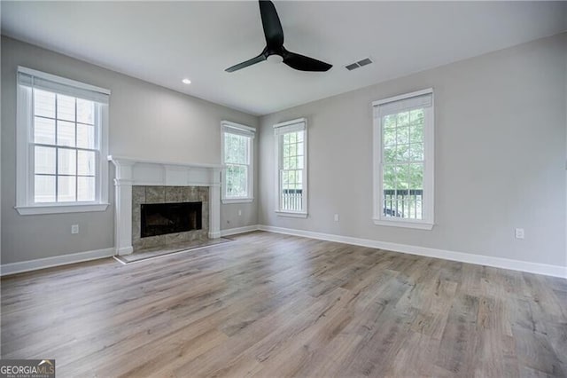 unfurnished living room featuring ceiling fan, visible vents, baseboards, and wood finished floors