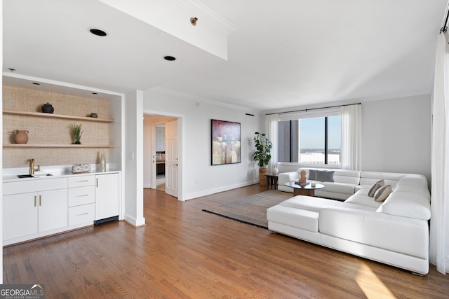 living room featuring ornamental molding, dark wood finished floors, and baseboards