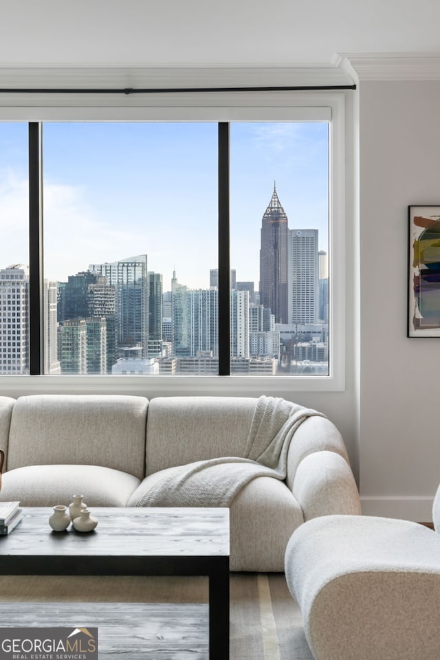 living room with ornamental molding, a view of city, and baseboards