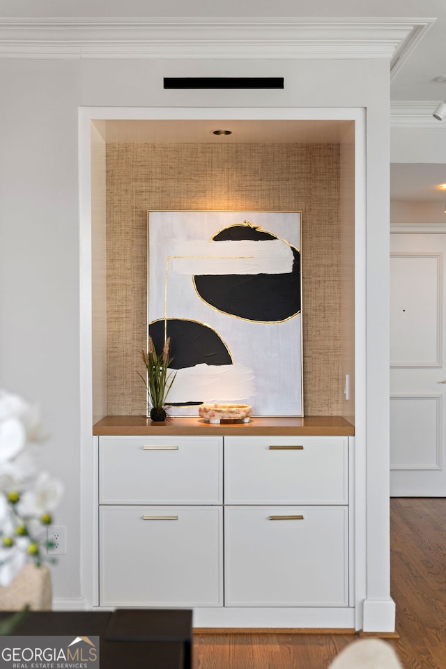 interior details featuring ornamental molding and wood finished floors