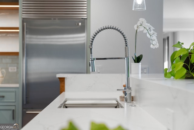 details with light countertops, a sink, and built in refrigerator