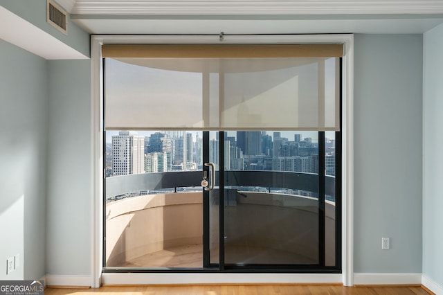 interior space with a balcony, visible vents, and a city view