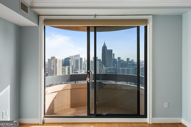 entryway with baseboards, plenty of natural light, visible vents, and a city view