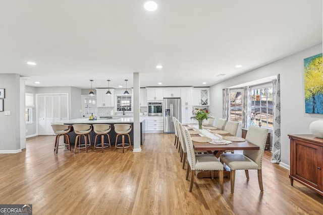 dining space with sink, a wealth of natural light, and light hardwood / wood-style floors