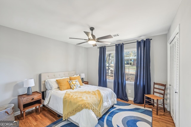 bedroom with hardwood / wood-style flooring, ceiling fan, and a closet