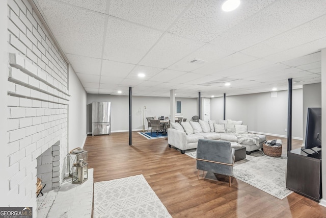 living room with a paneled ceiling and hardwood / wood-style floors