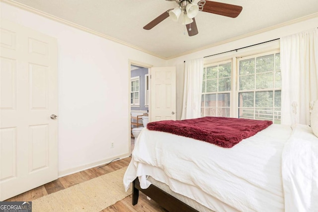 bedroom featuring light wood-type flooring, ceiling fan, crown molding, and ensuite bath