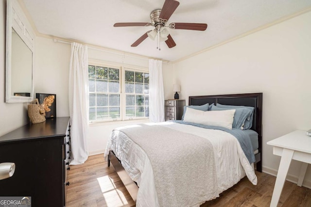 bedroom featuring ceiling fan, hardwood / wood-style floors, and crown molding