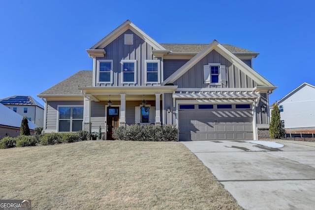 view of front of property with a garage, covered porch, and a front lawn