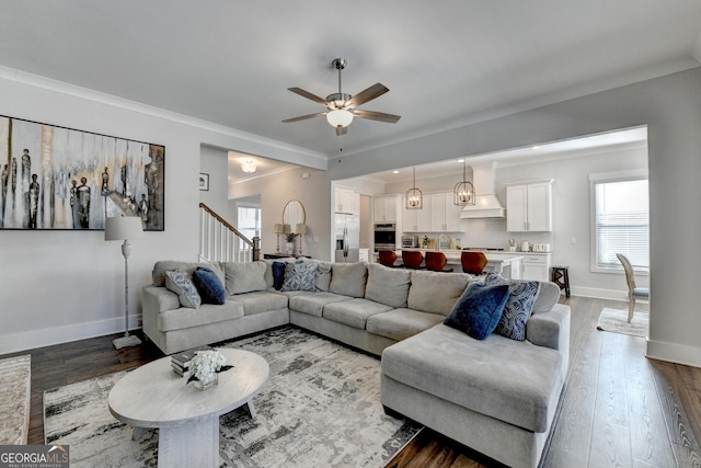 living room with ceiling fan, ornamental molding, wood-type flooring, and sink