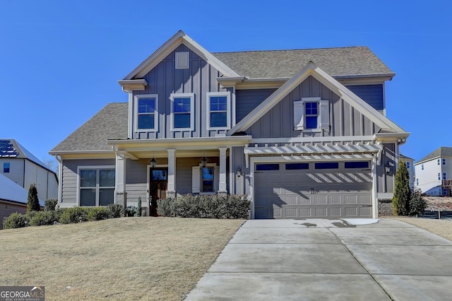 view of front of house featuring a garage, a front lawn, and covered porch