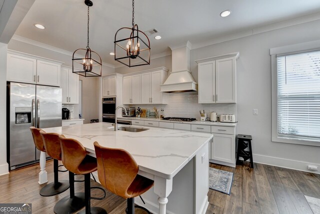 kitchen with white cabinetry, stainless steel appliances, sink, and custom exhaust hood